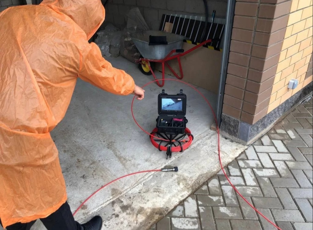 Мастер в защитном костюме проводит диагностику на объекте